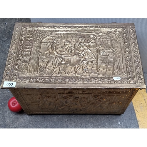 653 - Brass embossed storage chest with intricate figurative scenes and a hinged lid. Approximately 24