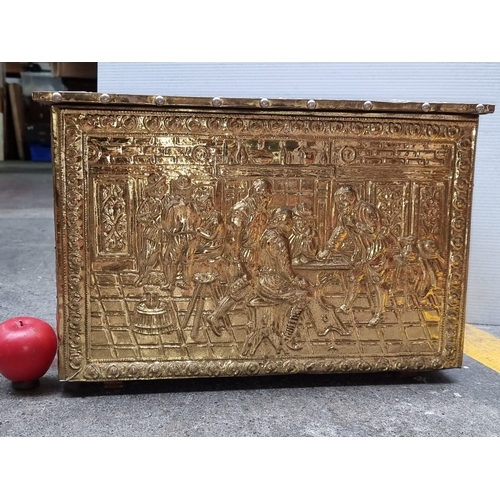 653 - Brass embossed storage chest with intricate figurative scenes and a hinged lid. Approximately 24