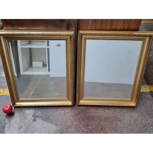 655 - Pair of gilt-framed mirrors, approximately 50 x 60 cm each, featuring ornate detailing and wooden ba... 