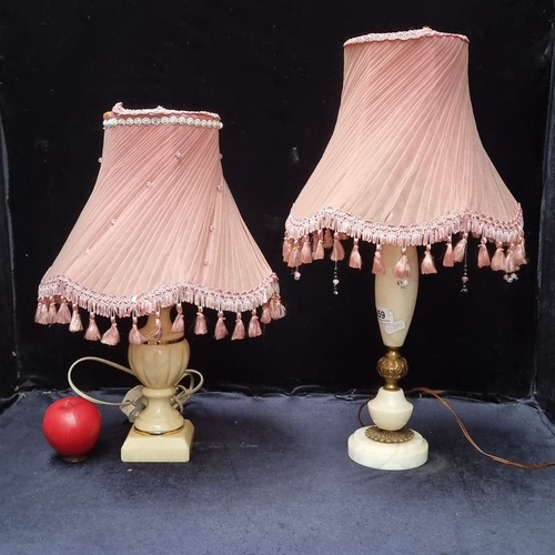 659 - Pair of vintage alabaster lamps with pleated pink fabric shades, adorned with tassels. Approximately... 