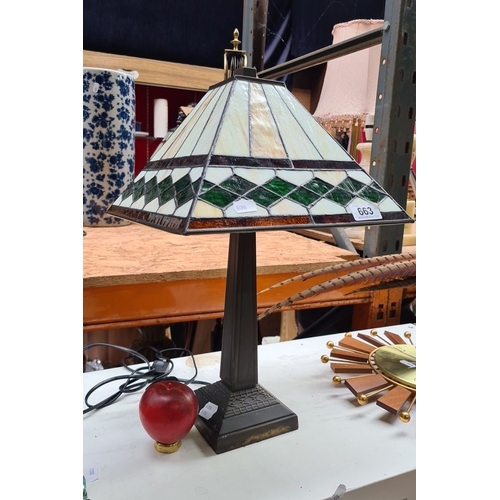 663 - Tiffany-style table lamp with stained glass shade featuring geometric green and cream patterns. Appr... 