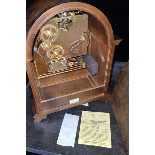 667 - A Franz Hermle Mahogany mantel clock with brass mechanism and decorative face, marked 