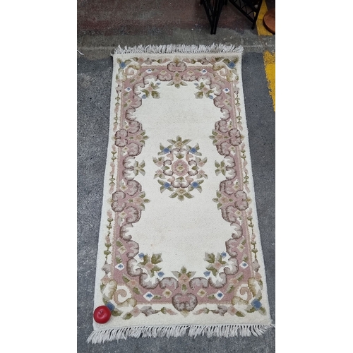 702 - A Chinese floral wool rug with intricate pink and green border design. Approximately 2 x 4 feet. Nic... 