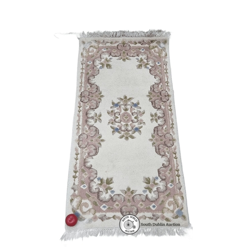 702 - A Chinese floral wool rug with intricate pink and green border design. Approximately 2 x 4 feet. Nic... 