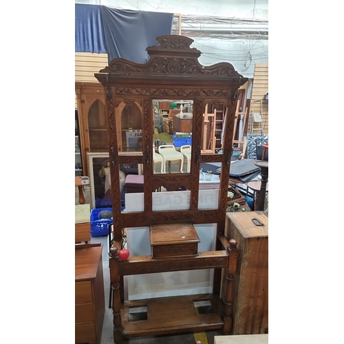 734 - A Victorian oak hall stand with intricate carvings and mirror paneling. Approximately 200 cm high, 1... 