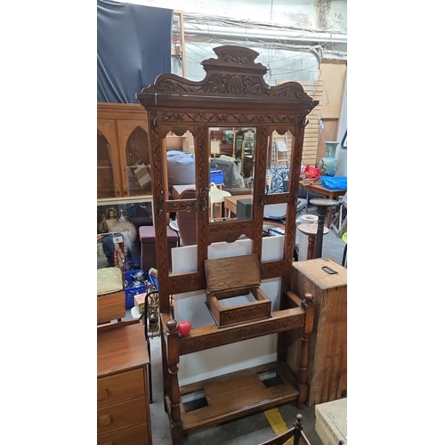 734 - A Victorian oak hall stand with intricate carvings and mirror paneling. Approximately 200 cm high, 1... 