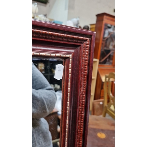 750 - Standing mirror with an ornately carved wooden frame, approximately 150cm high and 50cm wide, featur... 
