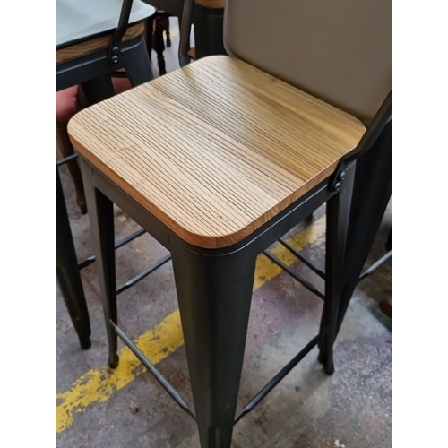 761 - Set of four industrial-style bar stools with black metal frames and wooden seats. Approximately 42 i... 
