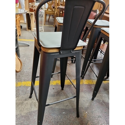 761 - Set of four industrial-style bar stools with black metal frames and wooden seats. Approximately 42 i... 
