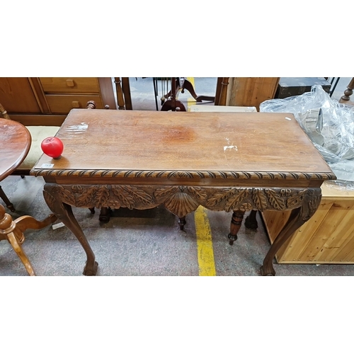 763 - Hand-carved wooden console table, featuring intricate leaf motifs and cabriole legs. Approximately 4... 