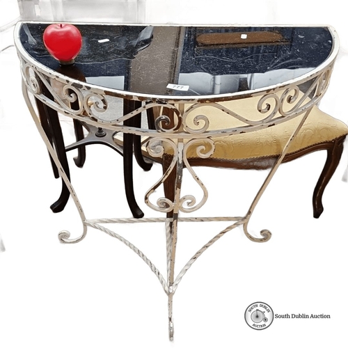 777 - Wrought iron and black glass demi-lune console table with decorative scrollwork. Approximately 75 cm... 