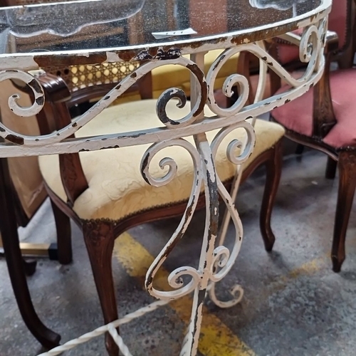 777 - Wrought iron and black glass demi-lune console table with decorative scrollwork. Approximately 75 cm... 