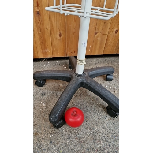 778 - White rotating metal magazine rack on wheels, approximately 170 cm high, featuring multiple display ... 
