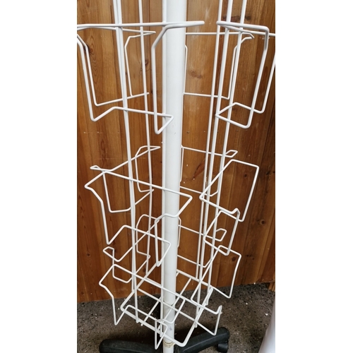 778 - White rotating metal magazine rack on wheels, approximately 170 cm high, featuring multiple display ... 