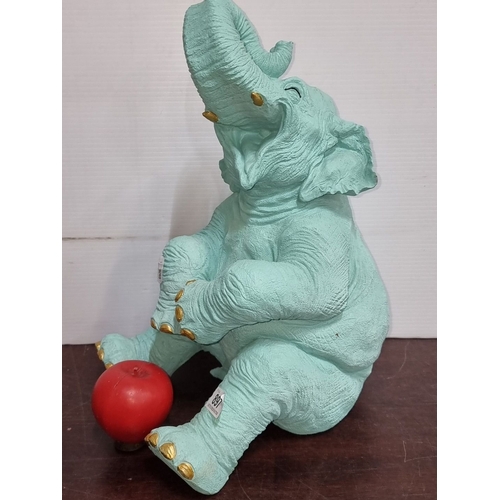 897 - Turquoise elephant sculpture with gold accents and apple detail. Approximately 25 inches high. Model... 