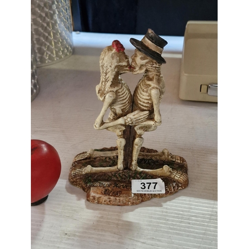 377 - An eerie cast heavy metal figure of skeleton lovers titled 