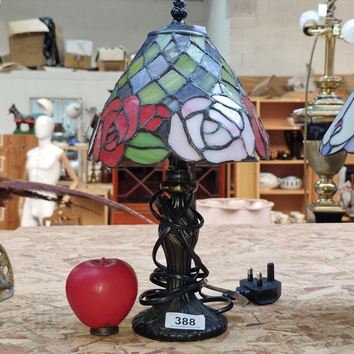 388 - A neatly sized Tiffany style table lamp featuring rose like motifs in rich deep tones with light pin... 