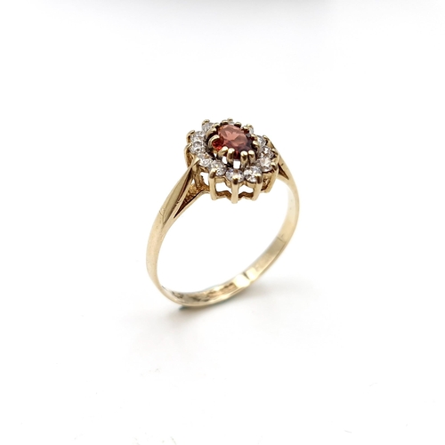 1122 - A lovey garnet stone ring with gem set cluster surround set in nine carat gold (375). Ring size - O.... 