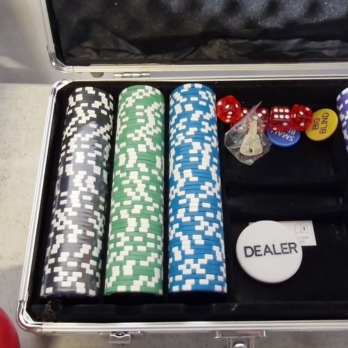 1079 - Poker set in aluminum case includes multicolored poker chips, dice, dealer button, and keys.