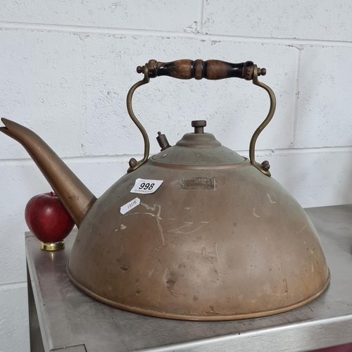 998 - An impressive large copper kettle featuring a long spout and turned wooden handle. Along with a bras... 