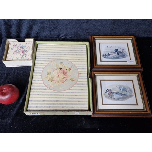 1054 - A lot of vintage items including floral placemats and coasters, along with two framed prints of mall... 