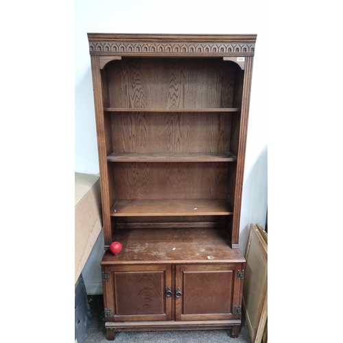 1105 - Antique oak bookcase with Gothic Revival details, three open shelves, and two lower cabinet doors. A... 