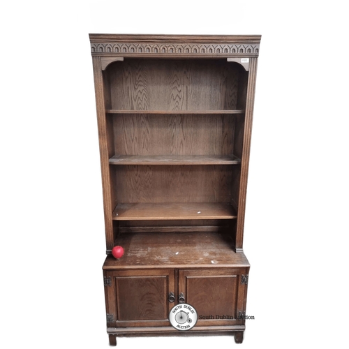 1105 - Antique oak bookcase with Gothic Revival details, three open shelves, and two lower cabinet doors. A... 