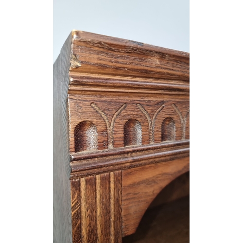 1105 - Antique oak bookcase with Gothic Revival details, three open shelves, and two lower cabinet doors. A... 