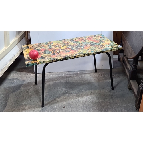 1179 - Retro coffee table with black metal legs and a vibrant comic-themed laminated top. Approximately 24 ... 