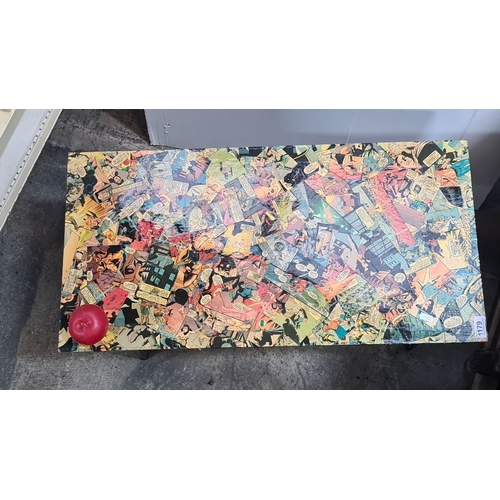 1179 - Retro coffee table with black metal legs and a vibrant comic-themed laminated top. Approximately 24 ... 