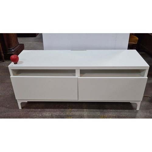 1186 - A low White modern low media unit with two open shelves and two drawers. Approximately 120 cm wide, ... 