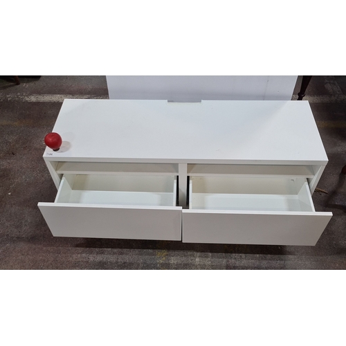 1186 - A low White modern low media unit with two open shelves and two drawers. Approximately 120 cm wide, ... 