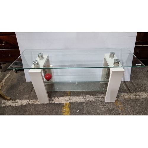 Glass console table with modern chrome accents and white supports