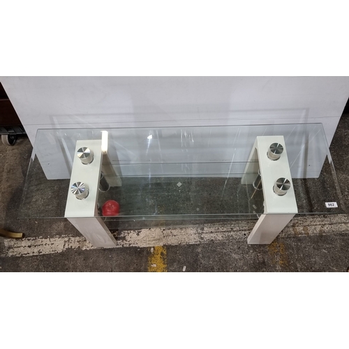 Glass console table with modern chrome accents and white supports