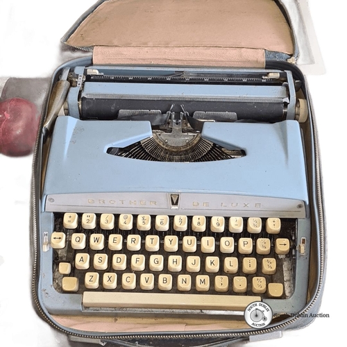 1234 - Vintage Brother De Luxe typewriter in a carry case, featuring cream keys and a pale blue body.
Previ... 