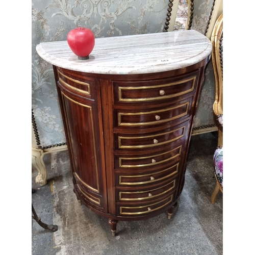 1263 - Star Lot : A Super bow-front chest with cold Italian marble top and seven drawers, accented by gold ... 