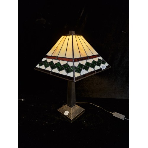 663 - Tiffany-style table lamp with stained glass shade featuring geometric green and cream patterns. Appr... 