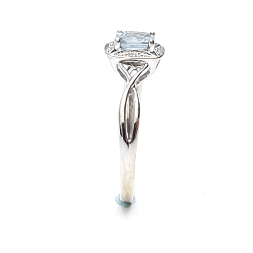 12 - Star lot : A lovely nine carat white gold aquamarine gemstone ring set diamonds  with a twist mount.... 