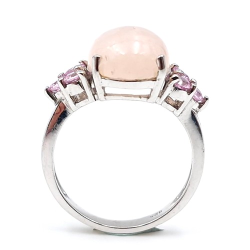 27 - A lovely pink rose quartz cabochon stone ring with gem set accents mounted in sterling silver. Size ... 