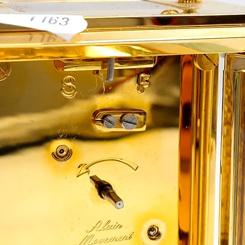 421 - A lovely example of a brass carriage clock by Jens Olsen with inspection aperture set with white ena... 