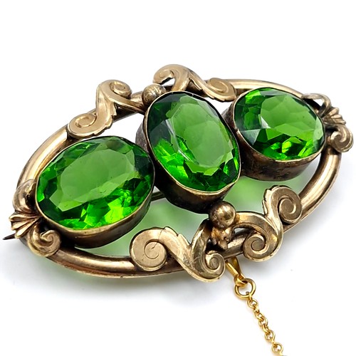 433 - An antique three stone peridot brooch set in pinch beck. Dimensions: 5 x 3 cms. Weight - 10 grams. S... 