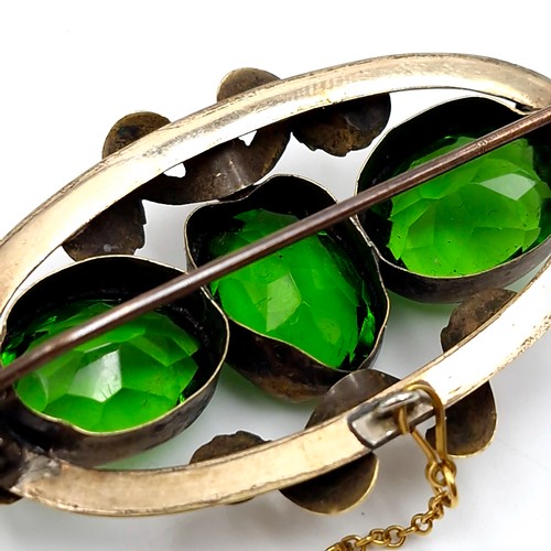 433 - An antique three stone peridot brooch set in pinch beck. Dimensions: 5 x 3 cms. Weight - 10 grams. S... 