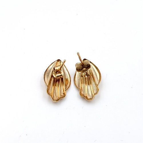 457 - A pair of nine carat gold shell designed stud earrings. - marks to backs. Total weight - 0.55 grams.... 