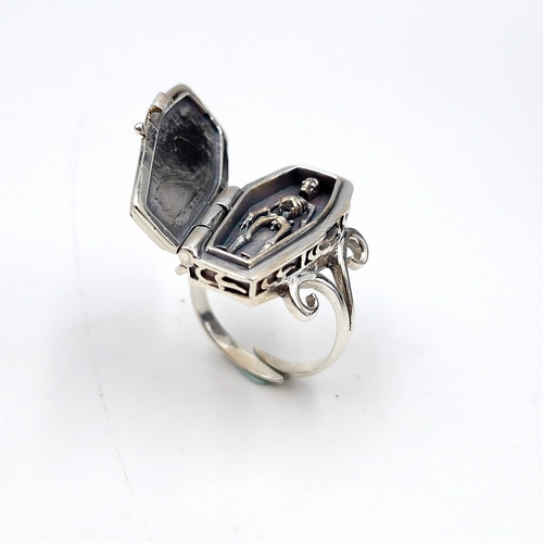 11 - Star Lot : An interesting sterling silver coffin ring with a hinged coffin mount housing a skeleton.... 