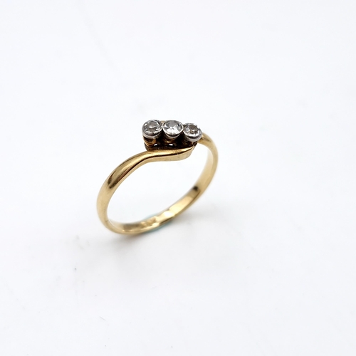 15 - Star Lot : An 18 carat gold ring set with three diamonds on a twist mount. Ring size - L. Weight - 1... 