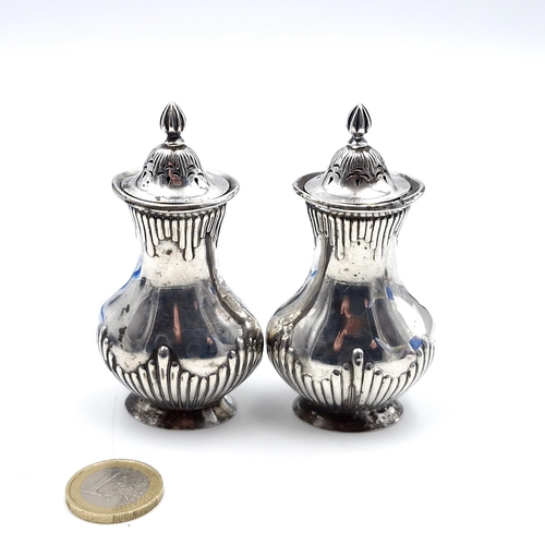 17 - A pair of antique sterling silver condiment items, set with attractive ribbed body with similar fini... 