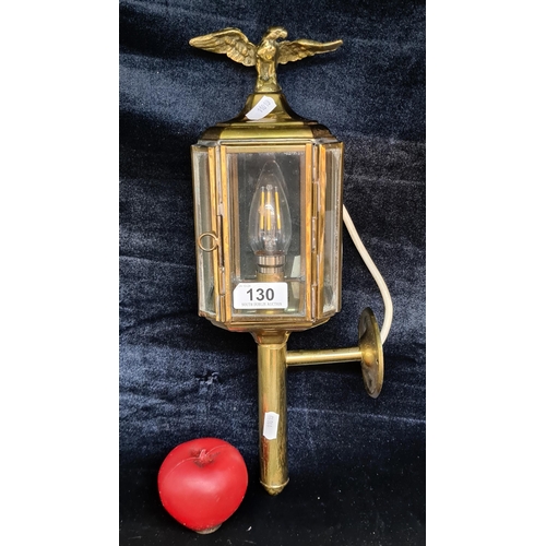 130 - A striking antique brass carriage wall light with eagle finial to top. Glass in good condition and l... 