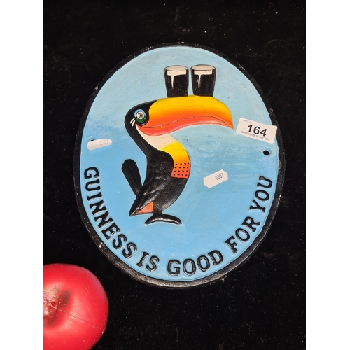 164 - A heavy cast metal oval wall plaque advertising Guinness featuring the iconic Toucan.