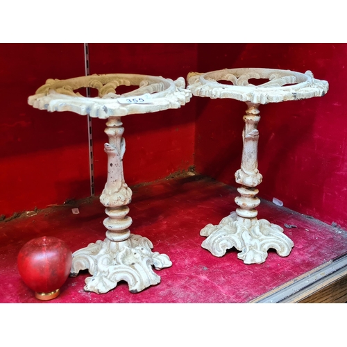 355 - A pair of cast metal pierced trivet stands with foliate scroll detail.