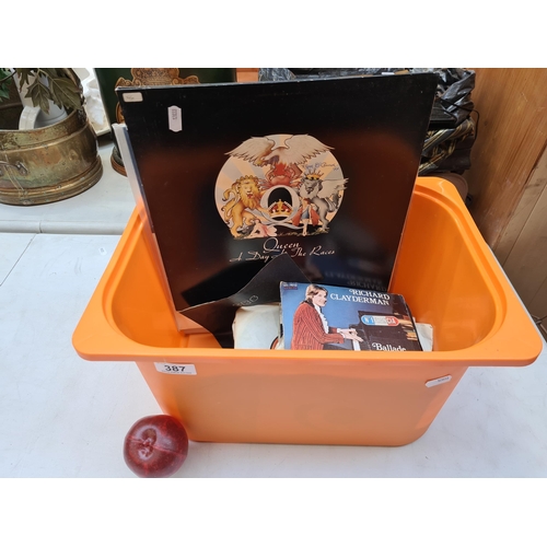 387 - A mixed lot of vinyl and seven inch records including artists such as Queen etc.